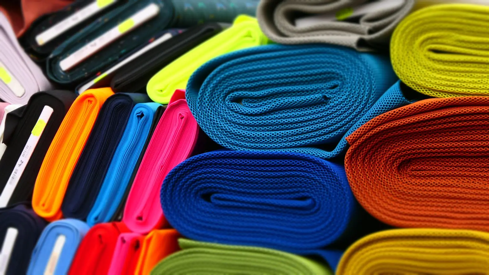 Rolos coloridos de tecidos organizados em uma loja
